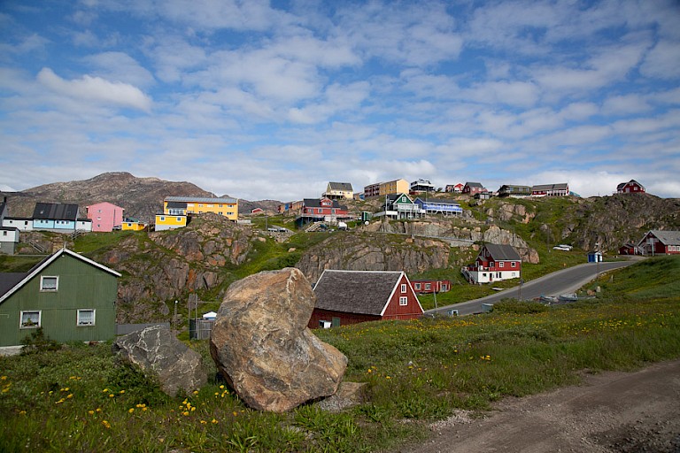 De kleurrijke huisjes van Maniitsoq liggen verspreid in in het bergachtige landschap.