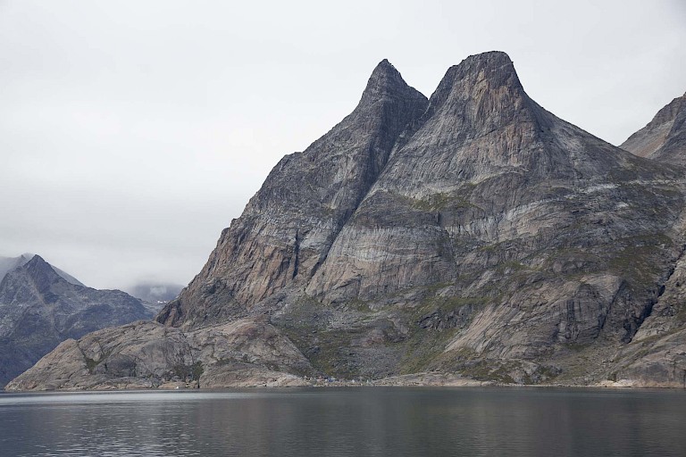 De kenmerkende gespleten berg met aan de voet de piepkleine huisjes van Aappilattoq