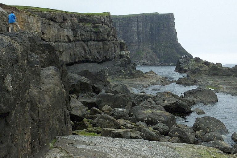 Enorme kliffen en rotsblokken aan de kust van Suðeroy.
