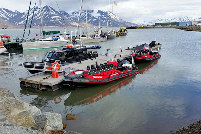 Overdekt excursiebootje en twee polarcirkelboten.