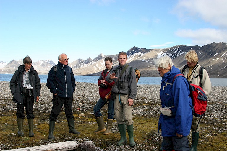 Aan land geeft de gids uitleg aan de passagiers.